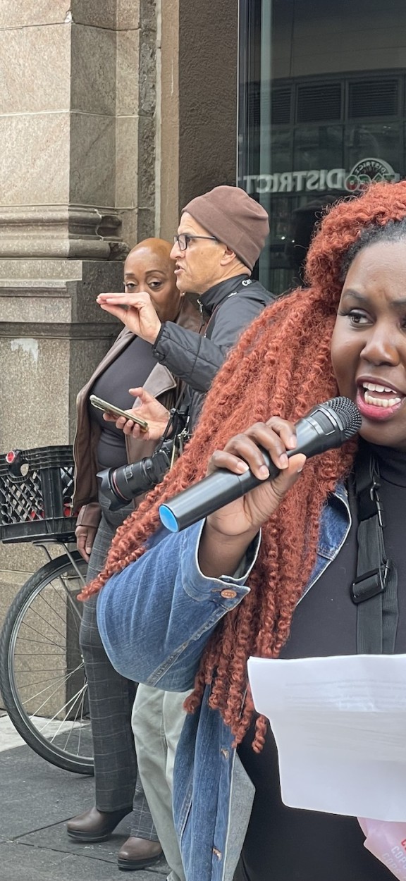 Nikki Grant speaks to the crowd wearing a denim jacket