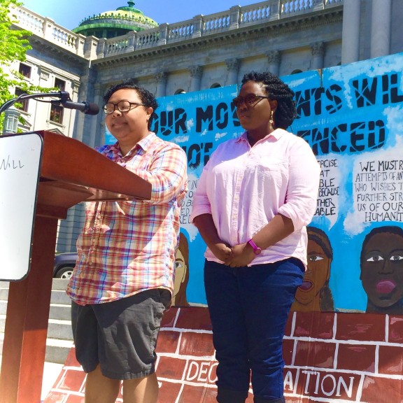 Kris Henderson and Nikki Grant of Amistad Law Project stand at the lectern at a rally