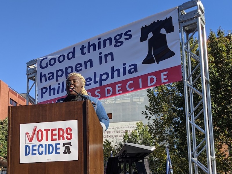 Nikki Grant stands at the podium at the Voters Decide rally